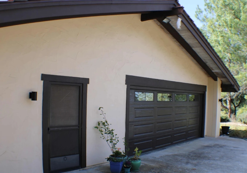 Technician aligning garage door safety sensors